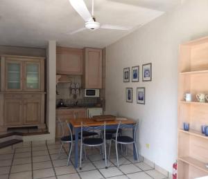 a kitchen with a wooden table and chairs at Cabañas ANANDA KANAN in Villa Giardino