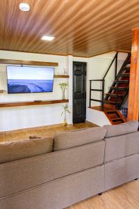 a living room with a couch and a flat screen tv at Casa Bajareque in Cerro Punta