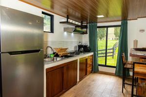 a kitchen with a stainless steel refrigerator and a table at Casa Bajareque in Cerro Punta