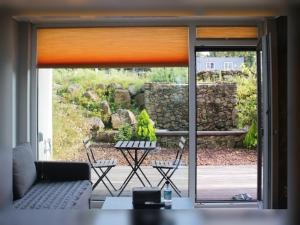 a living room with a couch and a sliding glass door at Jeju Teracehill Pension in Jeju