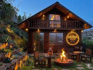 a log cabin with a fire pit in the yard at AURA View in Nuwara Eliya