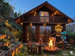 two people standing in front of a cabin with a fire at AURA View in Nuwara Eliya