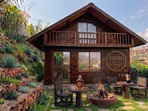 a log cabin with a fire pit in the yard at AURA View in Nuwara Eliya