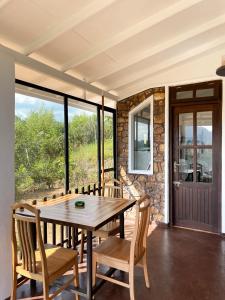 a dining room with a wooden table and chairs at Ella Repose in Ella