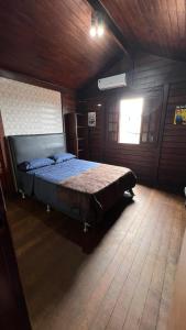 a bedroom with a bed in a wooden room at Casarão do Mar in Cabo Frio