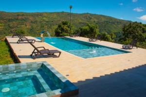 a swimming pool with two chairs and a swimming pool at HotelQuintaMaria in Barichara