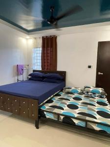 a bedroom with a large bed with a blue comforter at The SOS Pad in Pila
