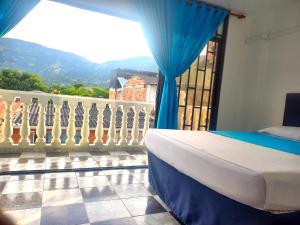 a bedroom with a bed and a balcony with a view at Hotel Los Balcones de Apulo in Apulo