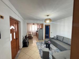 a living room with a couch and a kitchen at Kapllani Guest House in Durrës