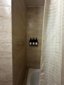 a bathroom with a shower with three bottles of soap at Vista Haus in General Sarmiento +19 photos