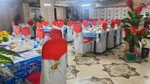a row of tables with red chairs in a banquet hall at Star International Rajshahi - Near Aam chattar in Rājshāhi