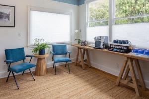 a room with two chairs and a desk and two windows at BytheSea Inn in Half Moon Bay +5 photos