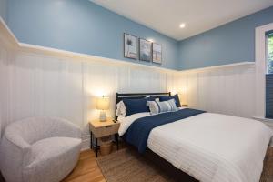 a bedroom with a bed and a chair at BytheSea Inn in Half Moon Bay