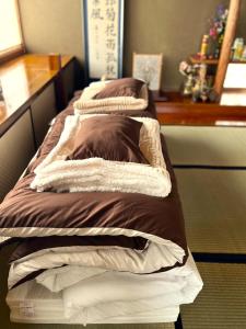 a couple of beds sitting in a room at ゲストハウスさちさんち in Wagō