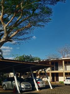 a parking lot with cars parked in front of a building at Hotel Estrella in Managua