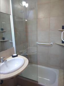 a bathroom with a glass shower and a sink at Cabañas ANANDA KANAN in Villa Giardino +9 photos
