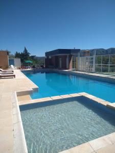 a large pool with blue water in a building at Cabañas ANANDA KANAN in Villa Giardino