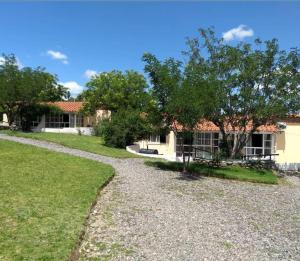 a house with a gravel road in front of it at Cabañas ANANDA KANAN in Villa Giardino