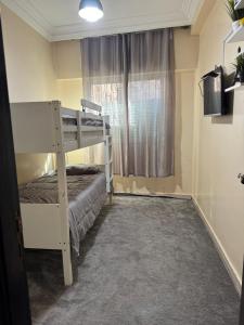 a bedroom with a bunk bed and a window at Apparemment Noucer in Derroua