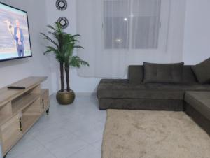 a living room with a couch and a tv at Apparemment Noucer in Derroua