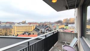 a balcony with two chairs and a view of a city at Møllergata apartment in Oslo