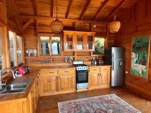 a kitchen with wooden cabinets and a stainless steel refrigerator at Lake Atitlán Panorama Chalets in San Marcos La Laguna