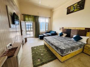 a bedroom with a bed and a living room at Himalayan Canvas khajjiar in Khajjiar 