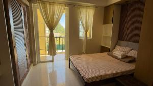 a bedroom with a bed and a large window at Suntrust88 Tower1-Unit 4Y in Baguio