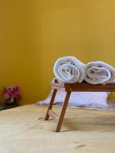 a pile of white towels sitting on a wooden table at Residence Cikaline Chambre d'hôte proximite du port de P-a-P in Pointe-à-Pitre
