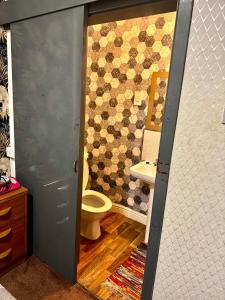 a bathroom with a toilet and a tiled wall at blackpool central lodge And Rooms in Blackpool +22 photos