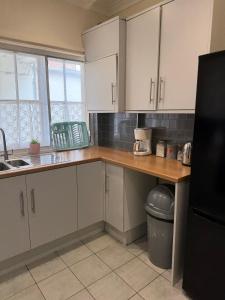 a kitchen with white cabinets and a wooden counter top at Cobble retreat high street in Hastings