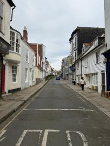 an empty city street with a woman walking down the street at Cobble retreat high street in Hastings