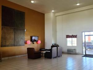 a lobby with two chairs and a table in a building at Budget Host Inn in Salina