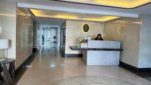 a woman standing at a counter in a hotel lobby at Suntrust88 Tower1-Unit 4Y in Baguio