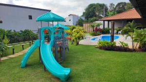 a playground with a slide and an umbrella at Pousada Recanto das Águas - Fama MG in Fama