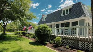 a house with a white fence and american flags at 8 Bedrooms With A Pool - 404 Fourth Avenue in West Cape May