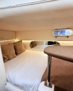 a bed in the middle of a room with a table at HouseBoat on the river-DouroHeritage in Porto