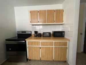 a kitchen with a counter and a stove and cabinets at Nice and Cozy House in the Greater Ponce Area in Ponce