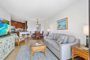 a living room with a couch and a kitchen at Penthouse Oceanview Vistas in Kihei