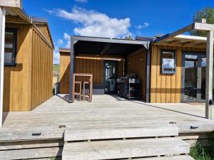 a wooden deck in front of a house at HavenRidge Alpaca Glamping Cabins in Kaiwaka