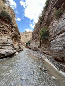 a river cuts through a rocky canyon at Gite Boutferda in Bou Tferda +18 photos