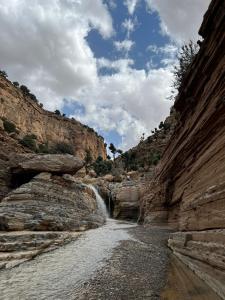 a river in a canyon with a waterfall at Gite Boutferda in Bou Tferda