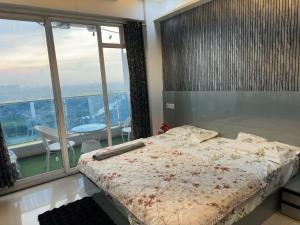 a bedroom with a bed and a balcony with a table at Luxury studios in Ghaziabad