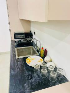 a kitchen counter with glasses and a plate and a sink at Luxury studios in Ghaziabad +1 photo