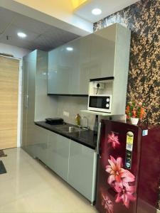 a kitchen with a refrigerator and a microwave at Luxury studios in Ghaziabad