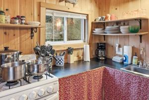 a kitchen with a stove with pots and pans on it at Davis Outpost Pet-Friendly Quiet Cabin w AC Screened Sunroom Walk to Trails in Otter Creek