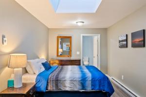 a bedroom with a bed and a table and a mirror at Phoenix Aerie Birds-Eye Harbor Views, Maritime Loft, Harbor Watch Sunrise Deck in Southwest Harbor