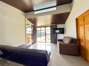 a living room with a couch and a tv at Paulos View Lodge in Colonia