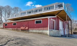 a red building with a balcony on top of it at Phoenix Aerie Birds-Eye Harbor Views, Maritime Loft, Harbor Watch Sunrise Deck in Southwest Harbor +34 photos