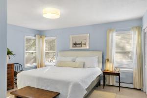 a bedroom with a large bed and two windows at Northern Nest MDI Lakefront Single-Level, Dual King Bedrooms & Private Dock in Pretty Marsh
